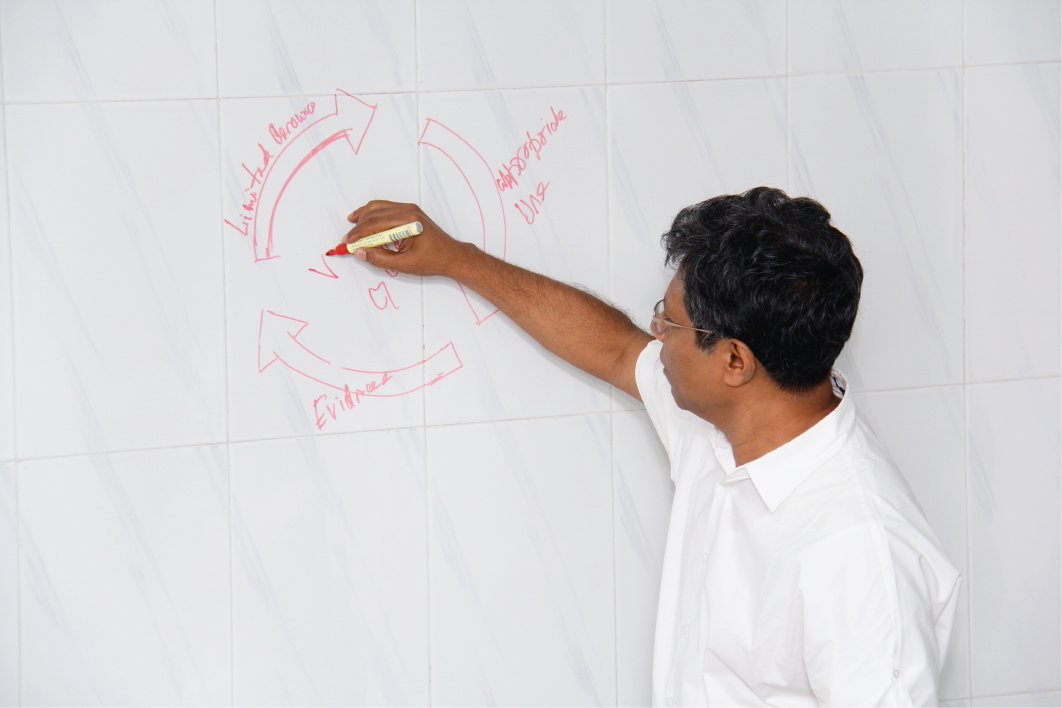 Dr. Samir Saha drawing a cycle on a tiled wall
